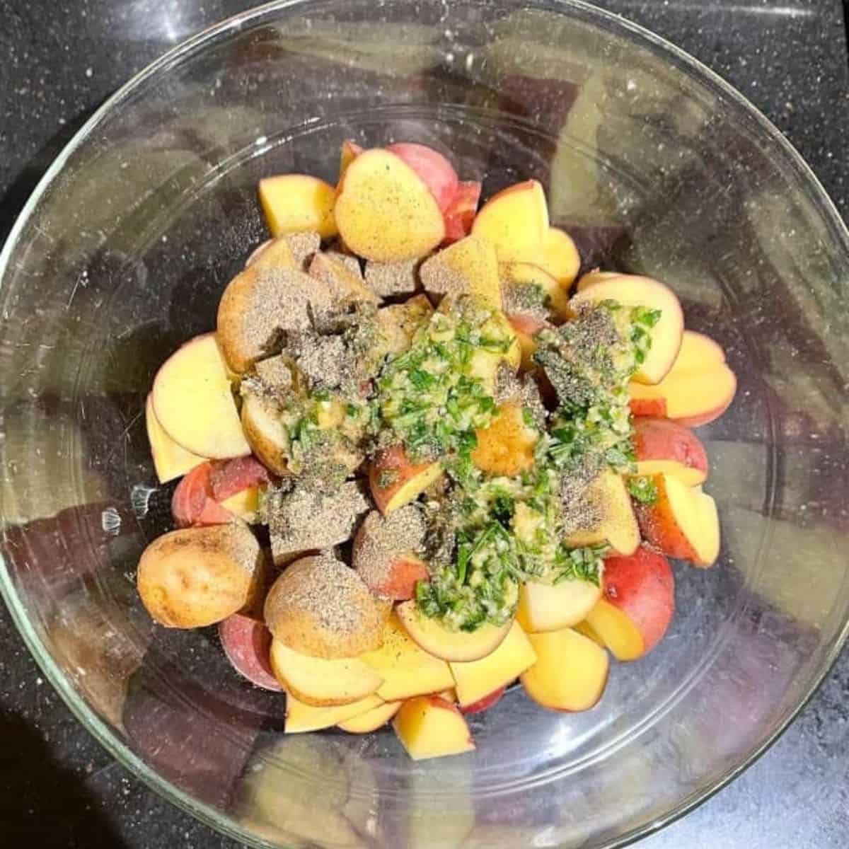 Marinade added to potatoes in bowl.