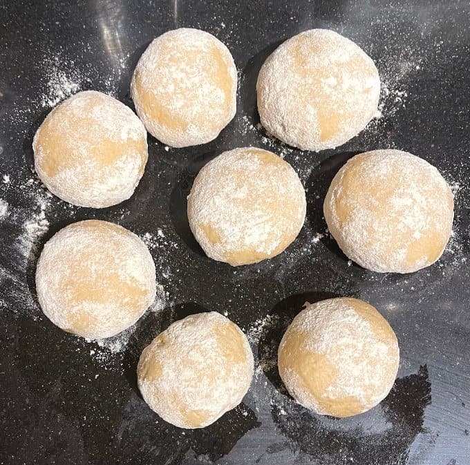 Whole wheat naan dough divided into eight balls.