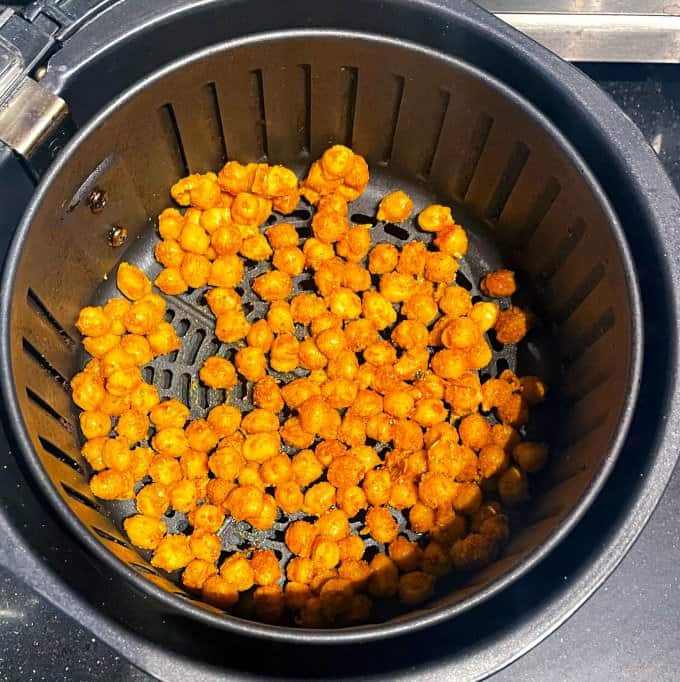Chickpeas in a single layer in air fryer basket.