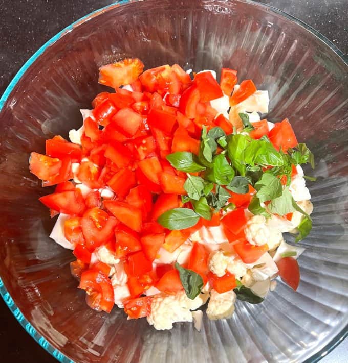 Tomatoes, basil and cauliflower in bowl.
