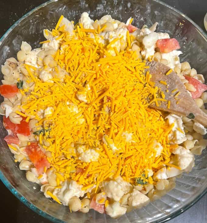 Cheddar cheese shreds added to bowl.