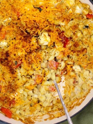 Baked cauliflower pasta in baking dish with spoon.