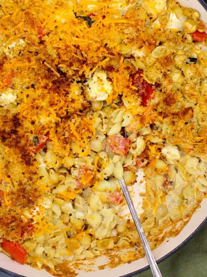 Baked cauliflower pasta in baking dish with spoon.