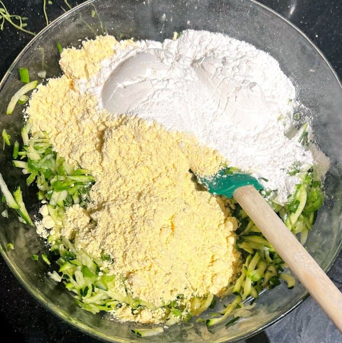 Rice flour and chickpea flour in mixing bowl with zucchini.