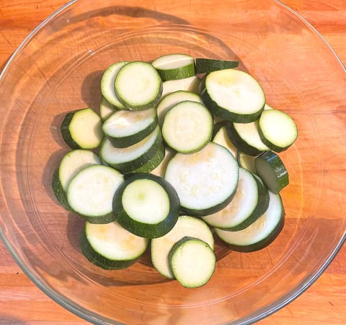 Zucchini chips in glass mixing bowl.