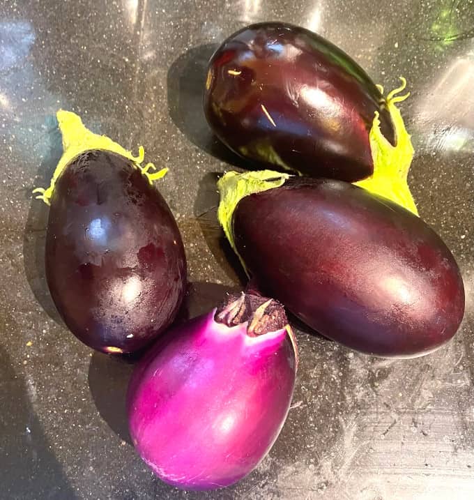 Four fresh eggplants.