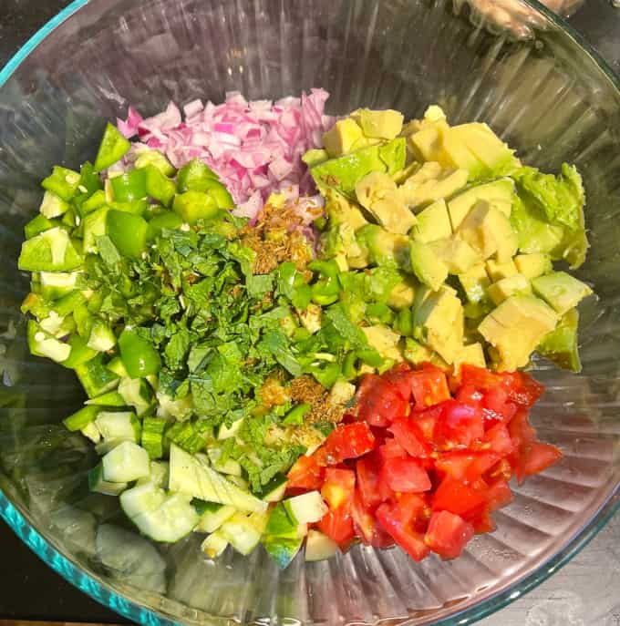 Ingredients for chickpea avocado salad in large bowl.