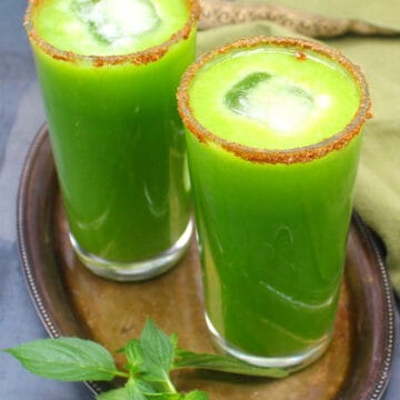 Two glasses of cucumber juice with a sprig of mint on the side.
