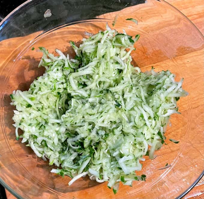 Grated cucumbers in bowl.