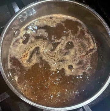 Tea leaves added to boiling water in saucepan/masala chai tea