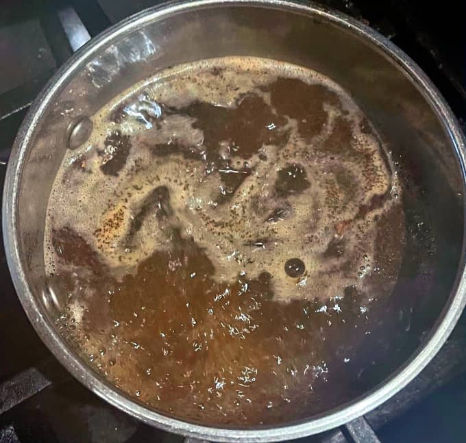 Tea leaves added to boiling water in saucepan/masala chai tea