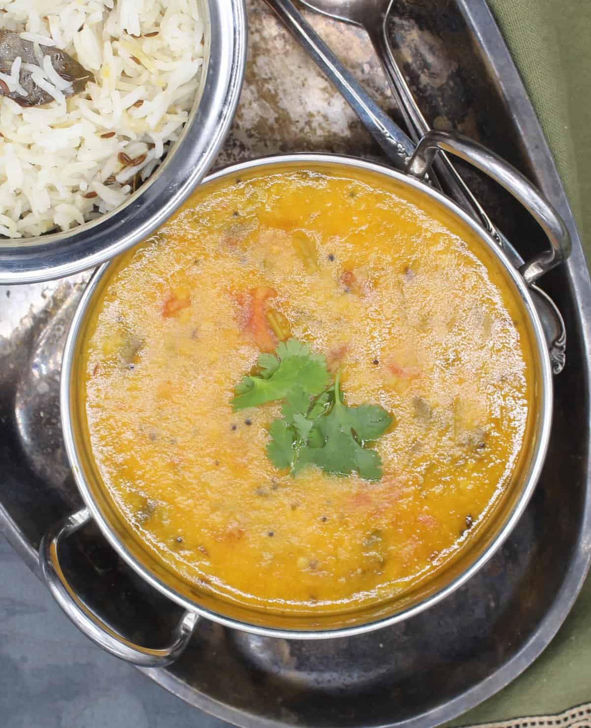 Indian dal in a karahi bowl with jeera rice. This is an authentic recipe. It's packed with protein, fiber, and it makes the perfect satisfying meal with rice or roti.
