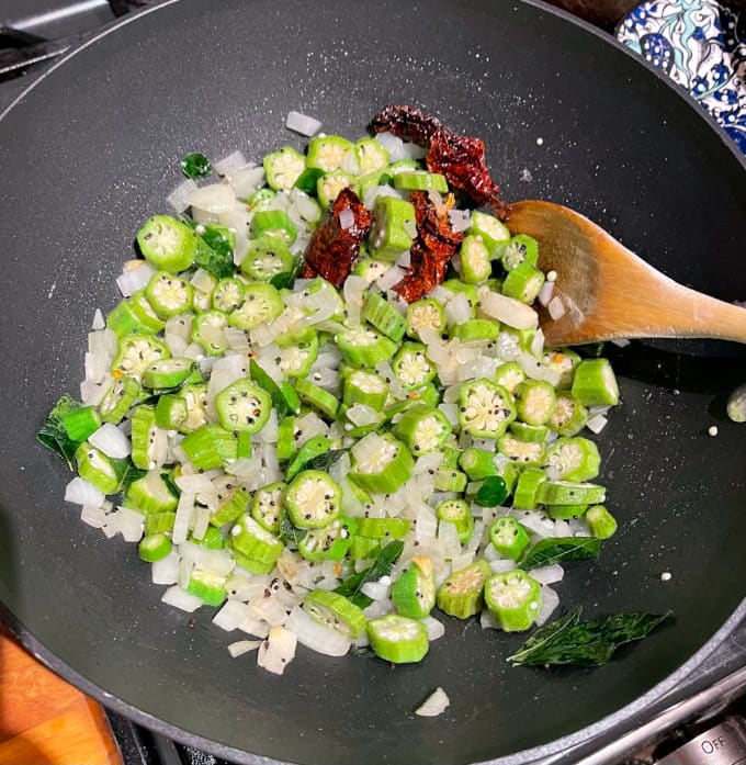 Okra or bhindi added to onions in wok/Bhindi sabzi