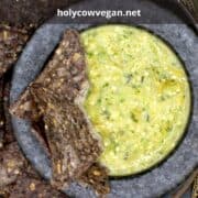 Salsa verde in molcajete with tortilla chips and text inlay that says "salsa verde. Mexican tomatillo green sauce"