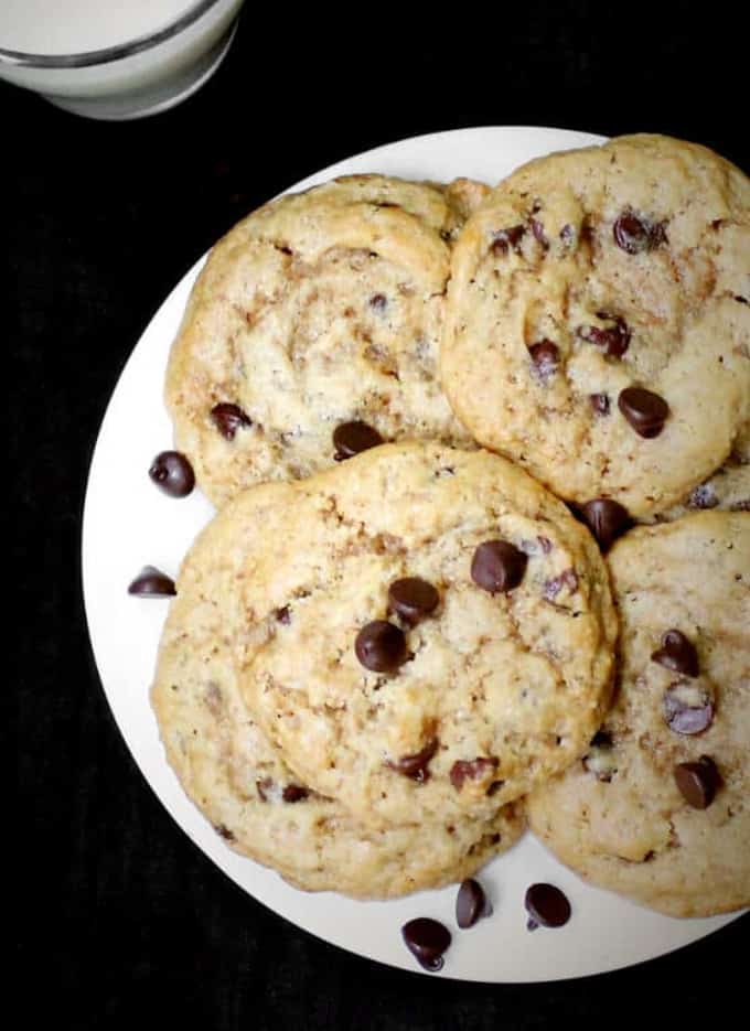 Simple vegan chocolate chip cookies with gooey chocolate chips on a white plate.