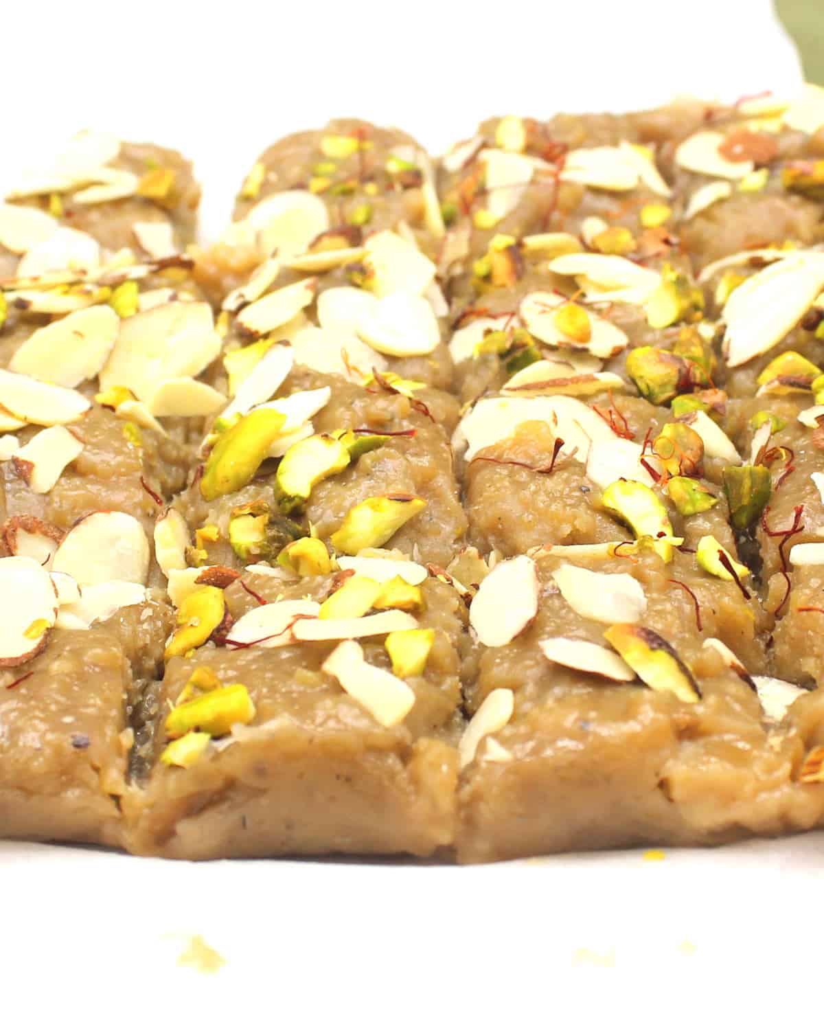 Vegan kalakand after cutting into slices on parchment paper.