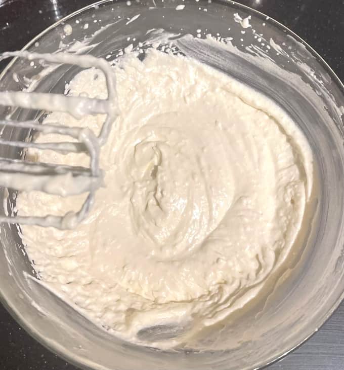 Cream cheese, vanilla, sweetener and other ingredients whipped in bowl.