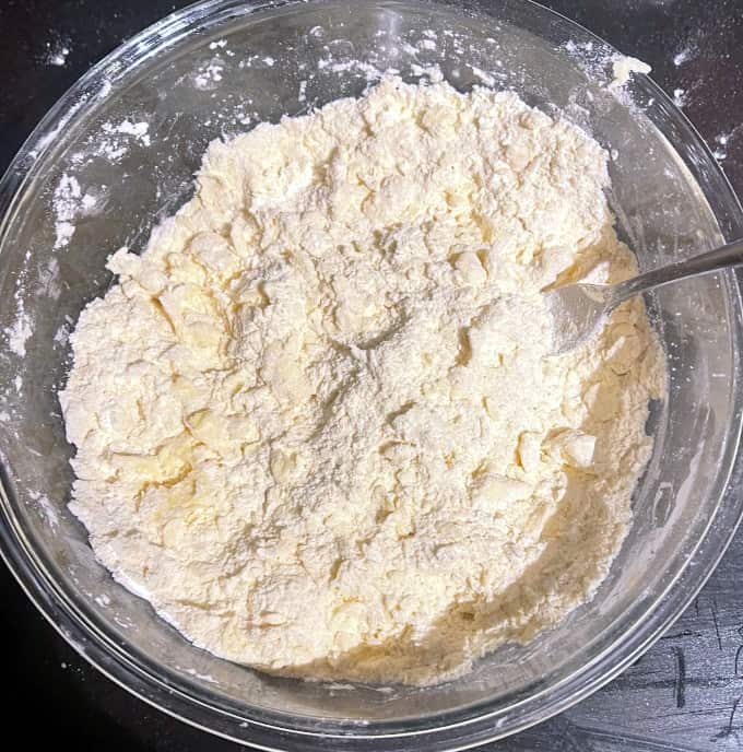 Butter cut into flour in glass bowl.