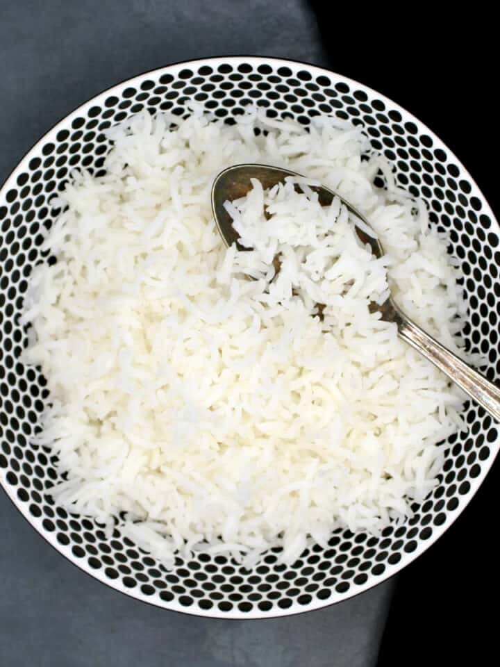 Perfect, fluffy grains of basmati rice in bowl with spoon.