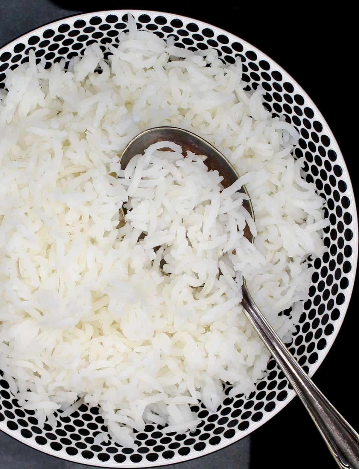 Perfectly cooked basmati rice in bowl with a spoon.