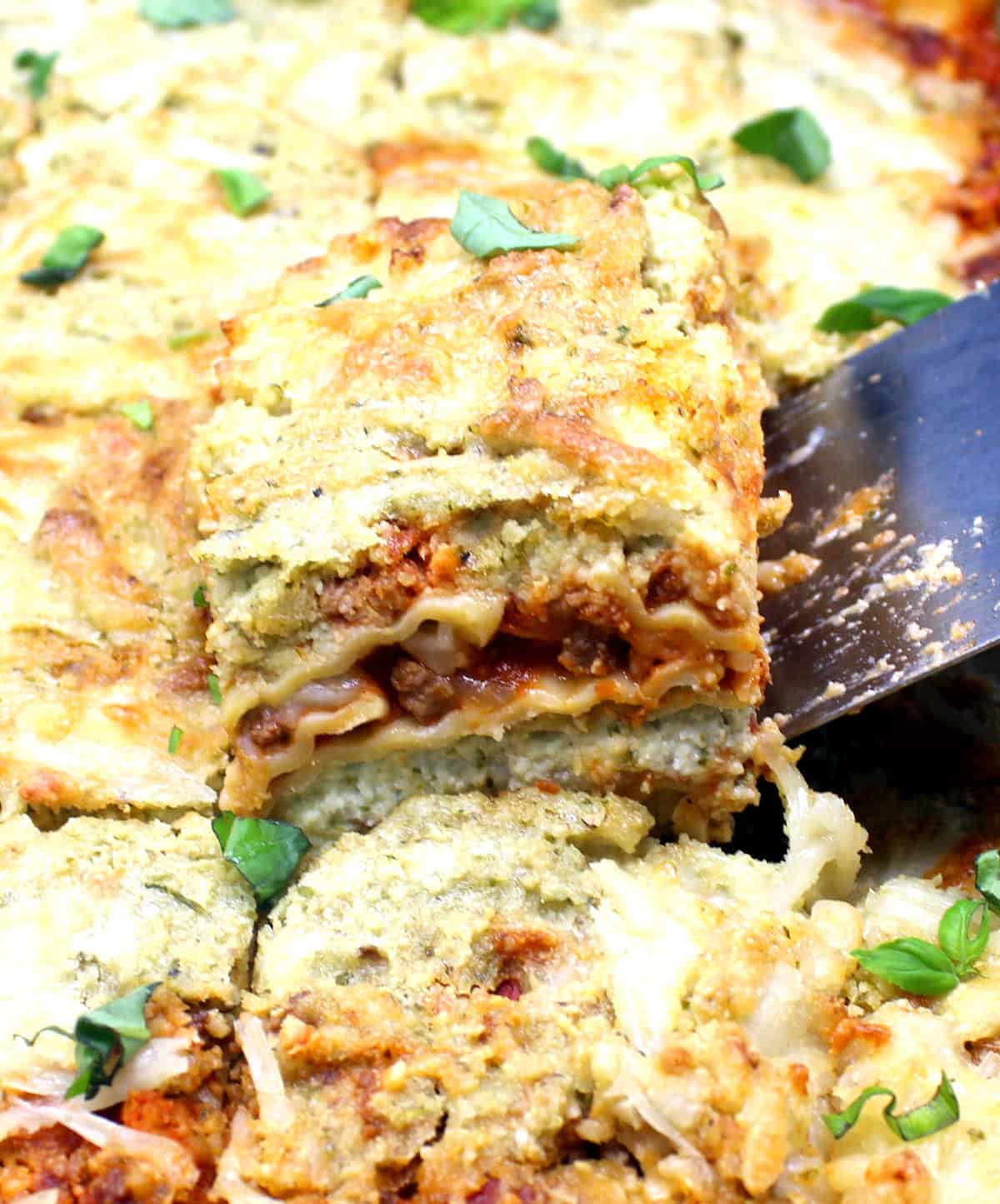 Vegan lasagna being lifted out of pan with spatula.