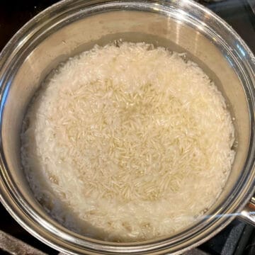 Rice boiling in water in saucepan.