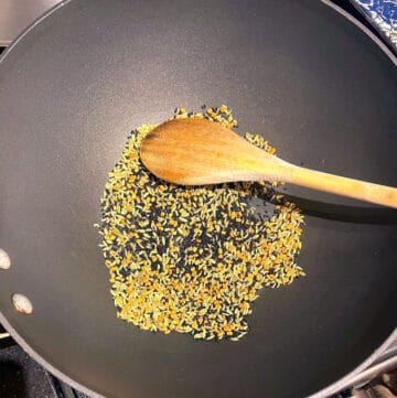 Pickling spices being toasted in skillet.