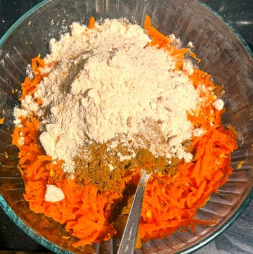 Salt and pickling spices added to carrots and ginger in bowl.