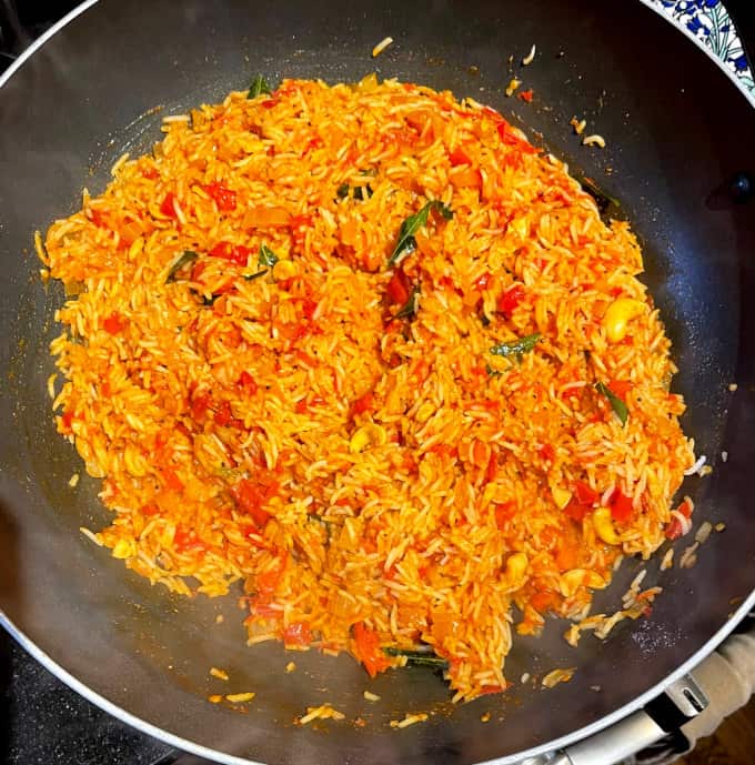 Tomato rice mixed in wok.