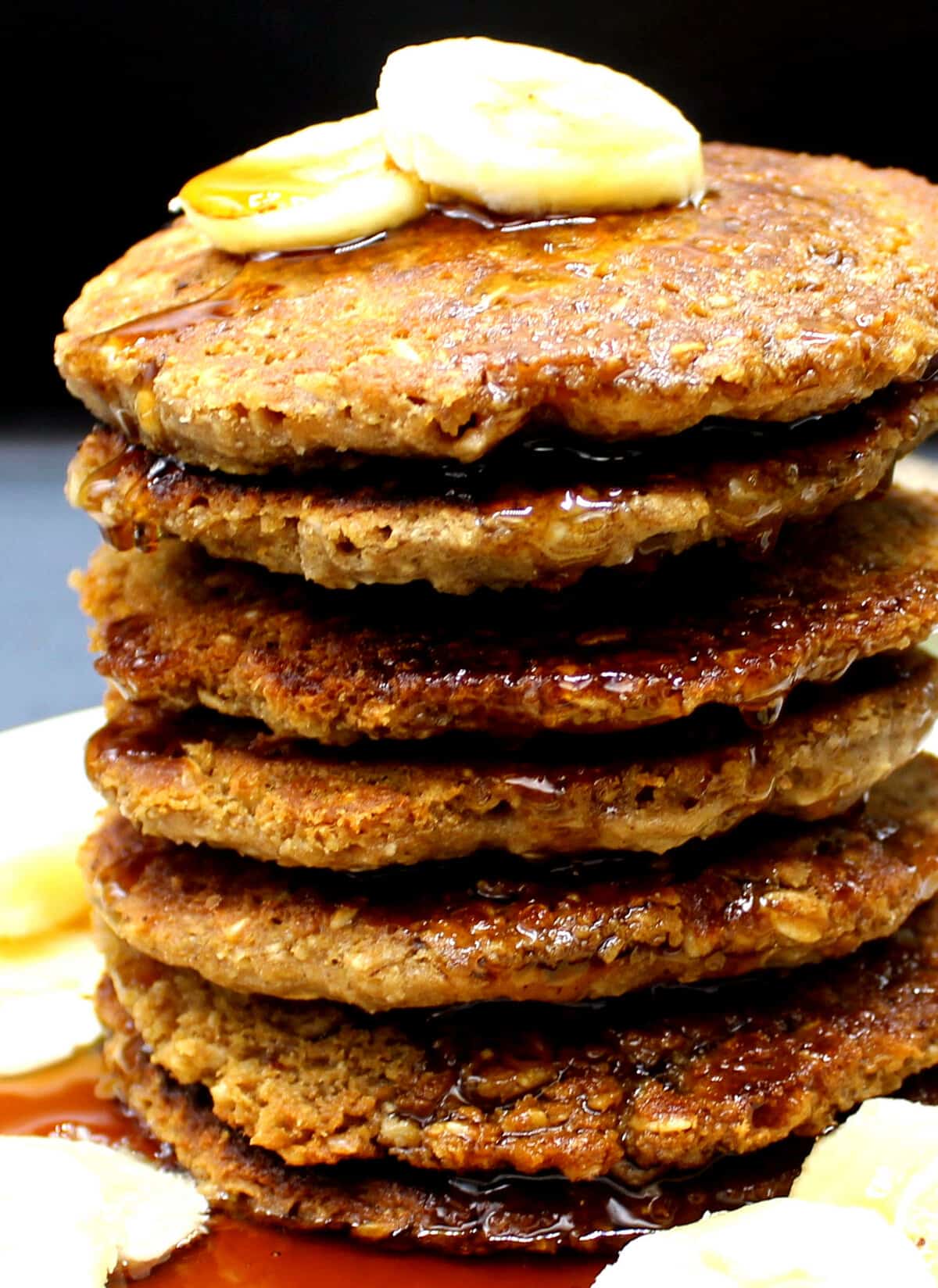 A stack of vegan oatmeal pancakes with slices of banana.