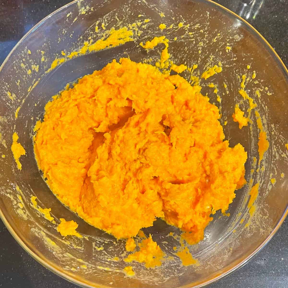 Mashed orange sweet potatoes in bowl.
