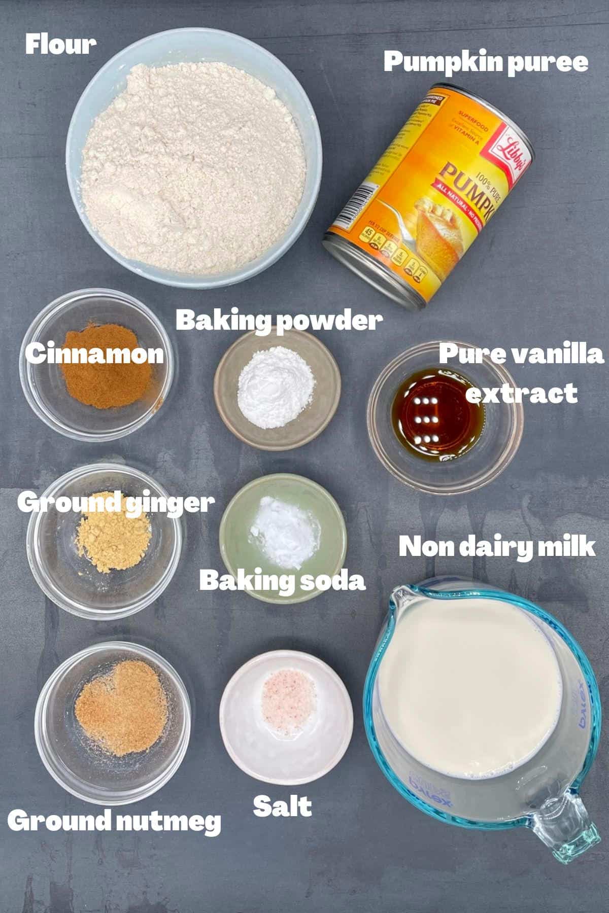 All ingredients for vegan pumpkin pancakes in bowls and cups.