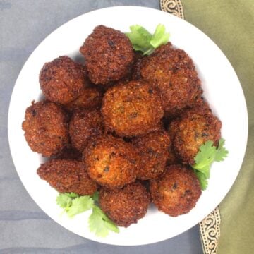 Akara or black eyed pea fritters in white bowl with cilantro.