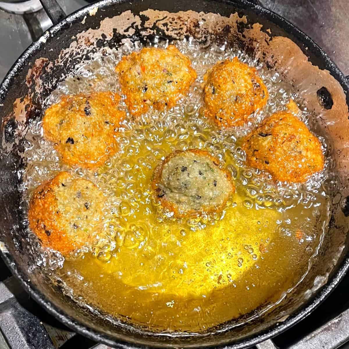 Akara deep frying in frying pan.
