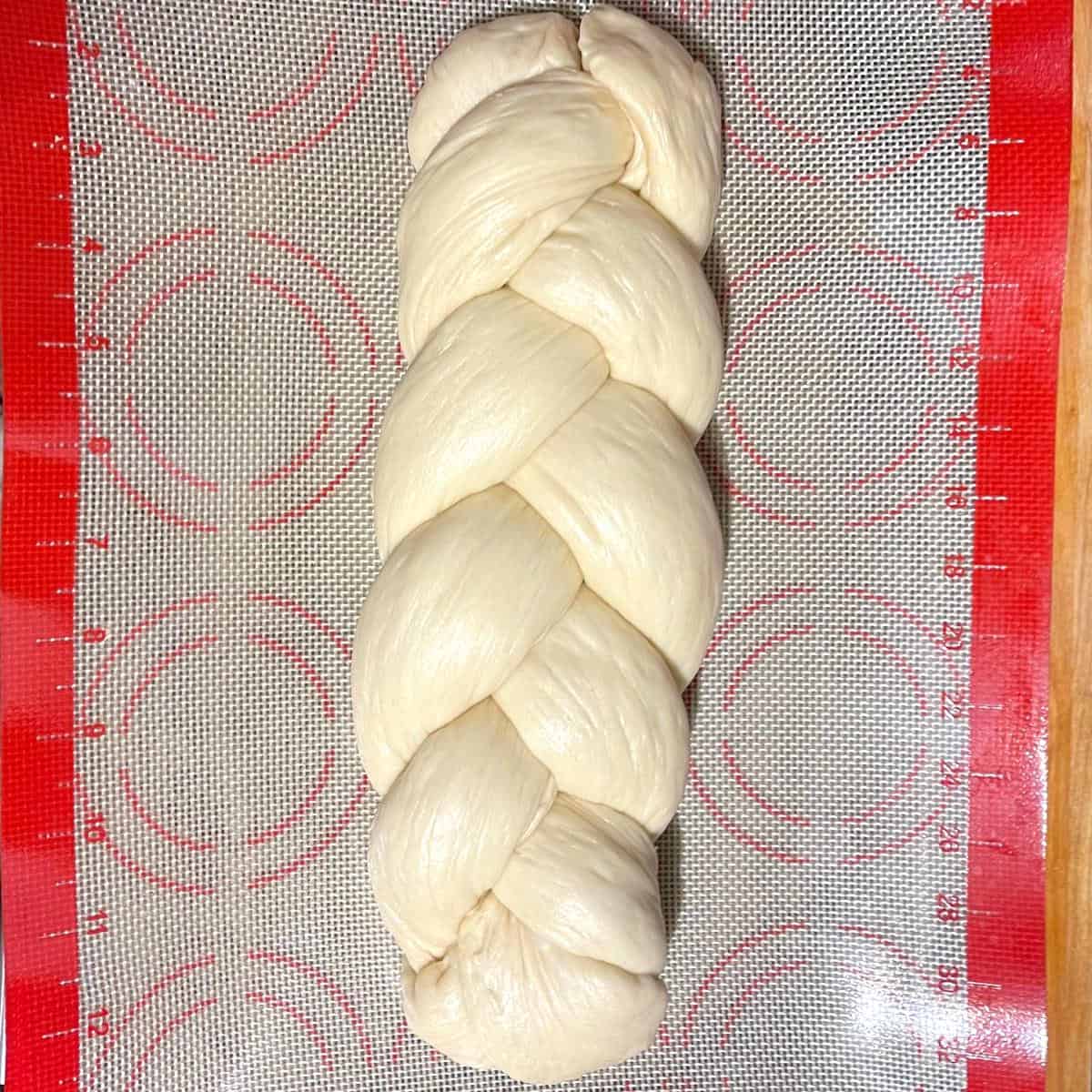 Vegan challah bread after braiding on silpat sheet.