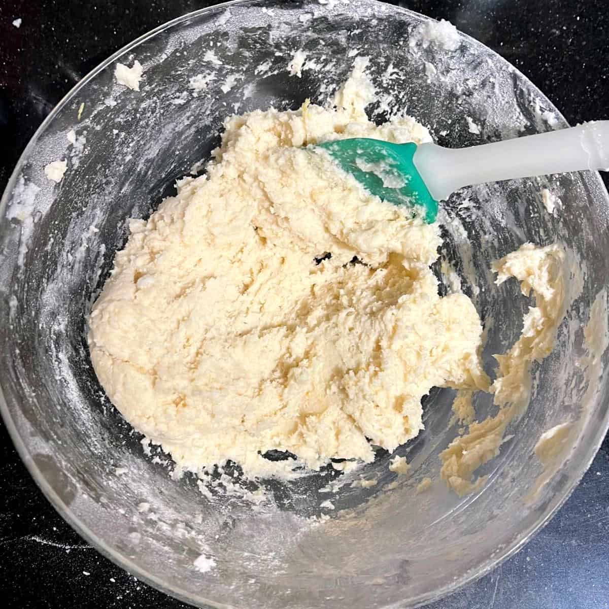 Cookie dough in bowl with spatula.