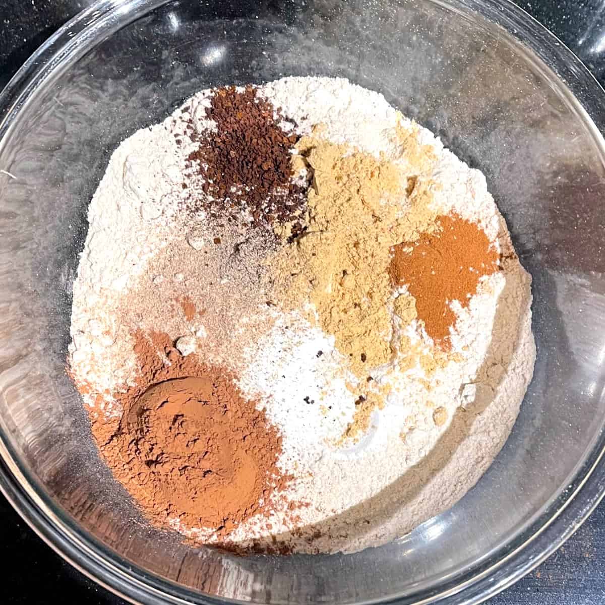 Dry ingredients for chocolate ginger cookies in glass bowl.