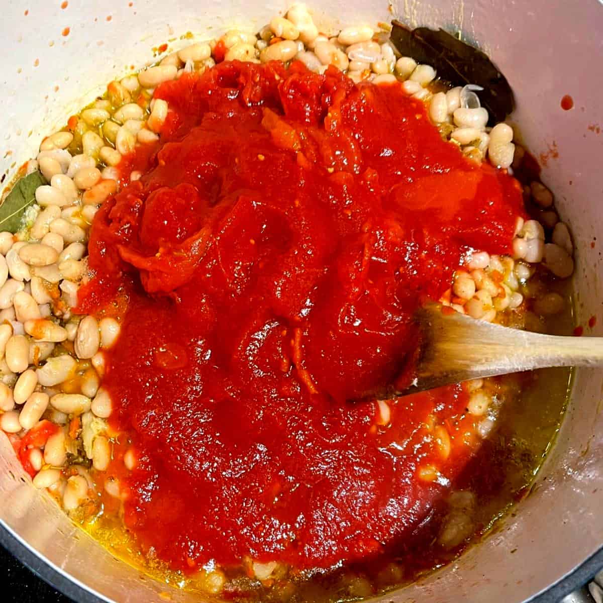 Tomatoes added to pot with beans.
