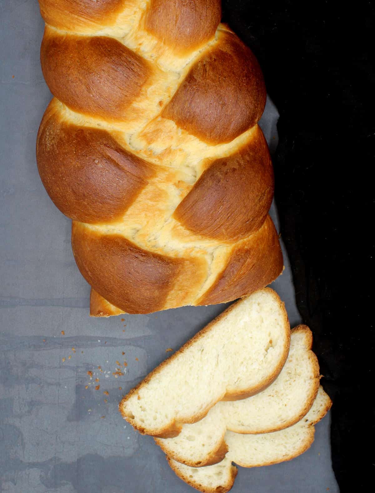 Sliced vegan challah bread on gray background.