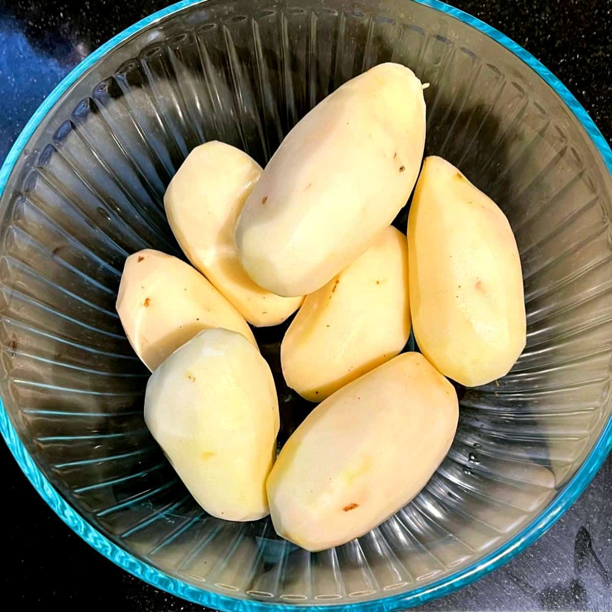 Peeled potatoes in bowl.