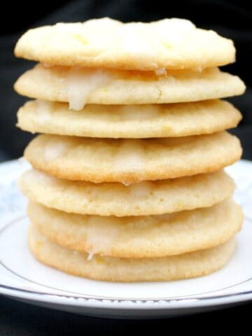 Vegan lemon cream cheese cookies stacked on china plate.