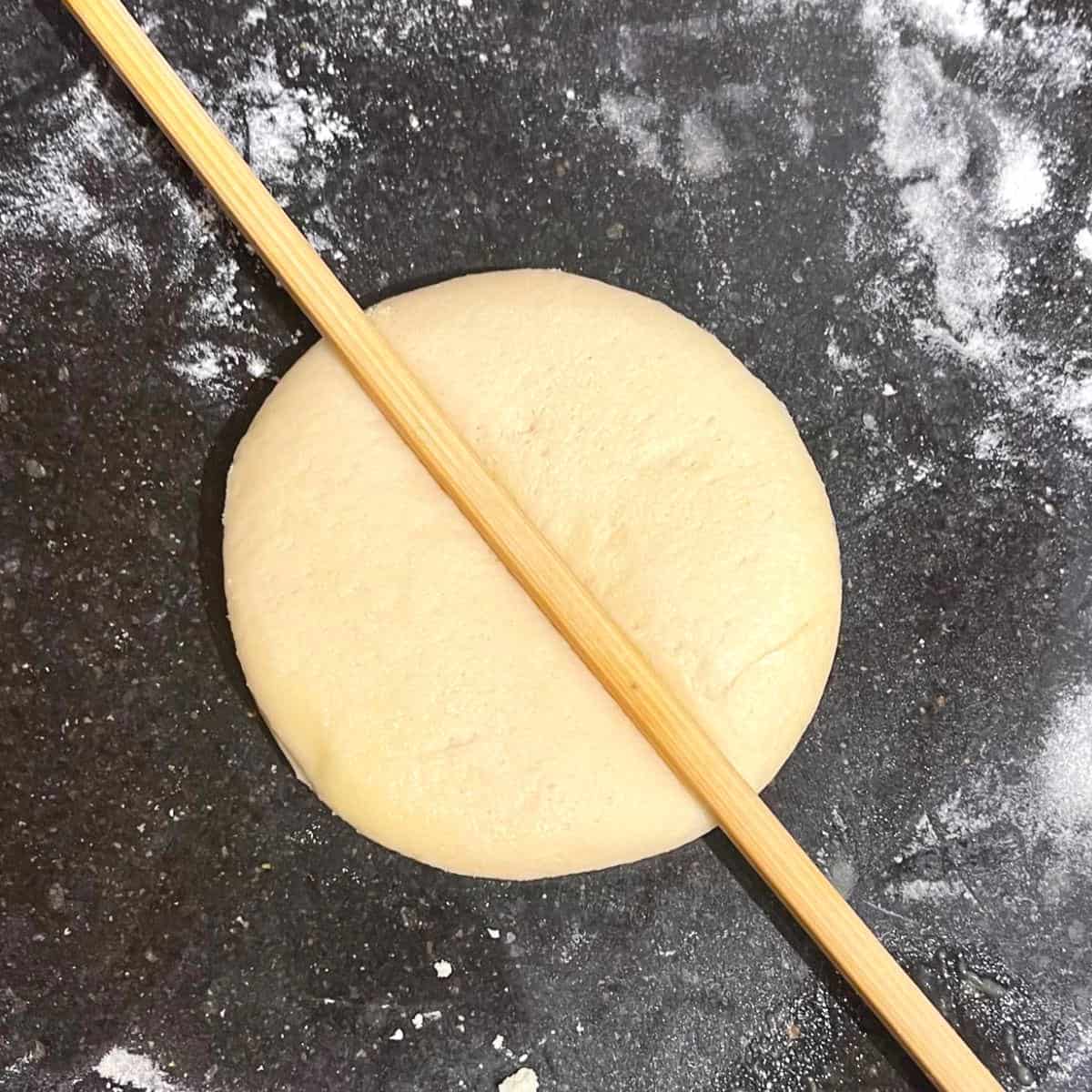 Chopstick pressed into each dough round to create an indentation in center.