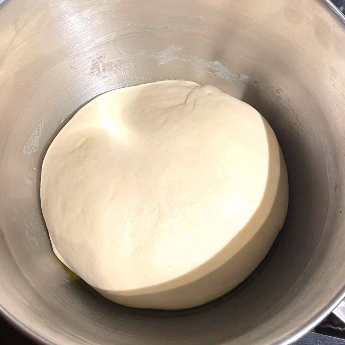 Kneaded dough after rising in steel bowl.