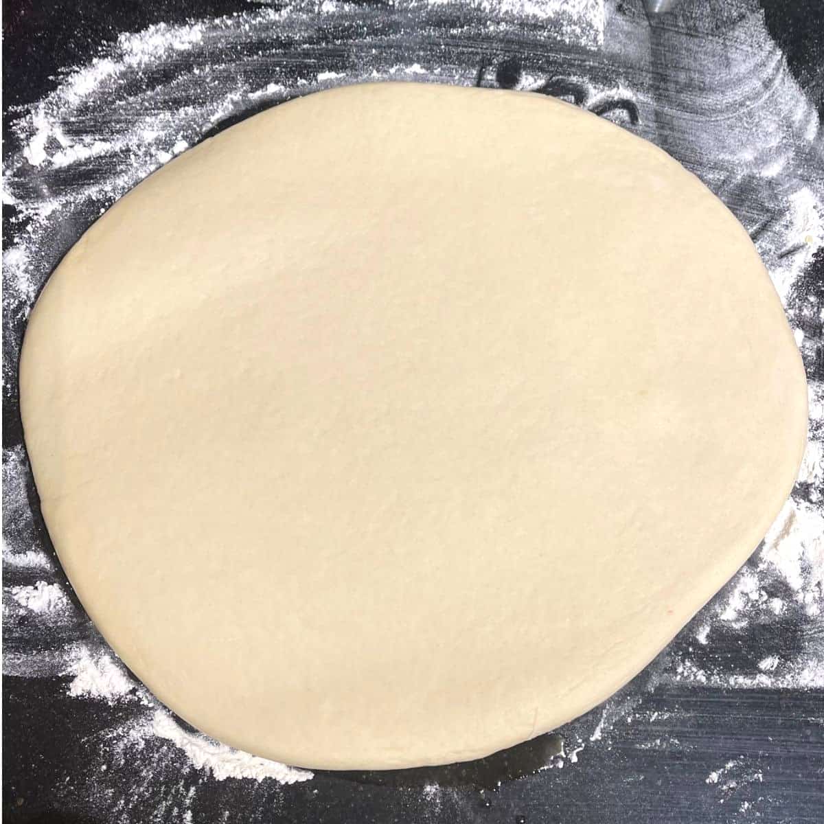 Rolled parker house roll dough on floured surface.