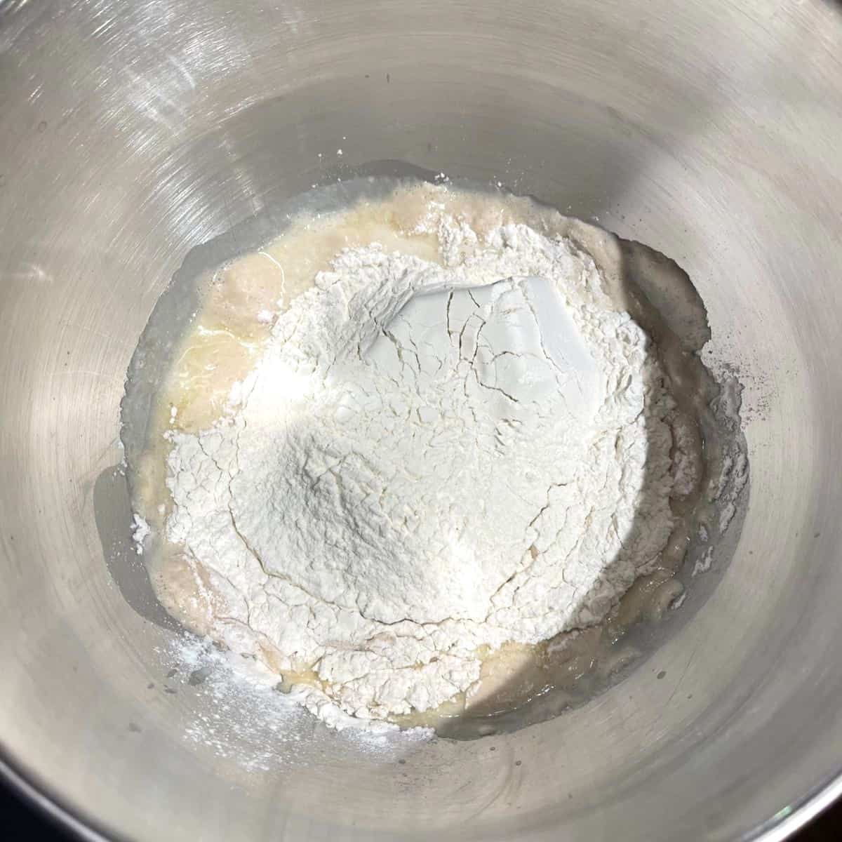 Flour added to bowl with yeast and soymilk mixture.