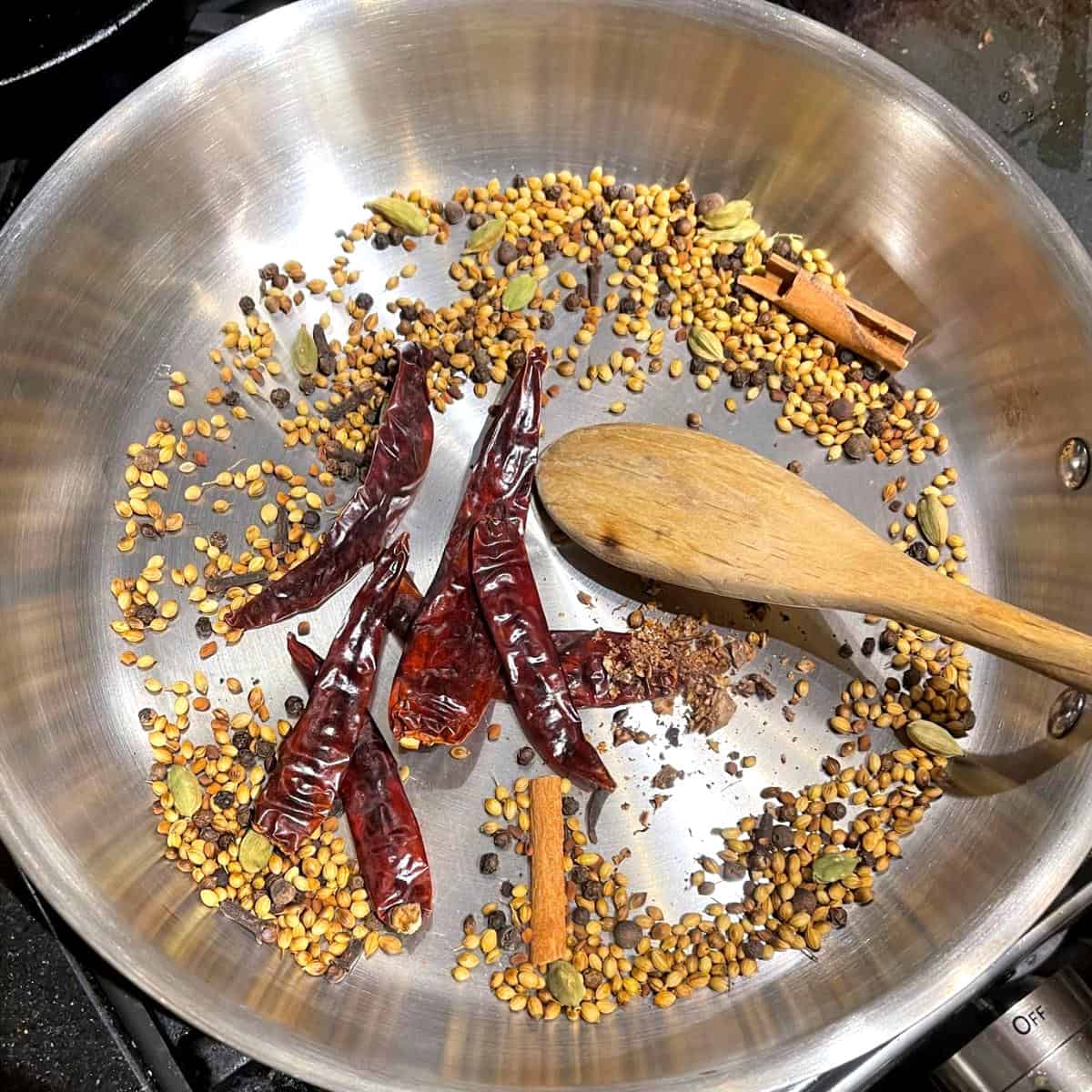 Whole spices after toasting with chili peppers and nutmeg added.