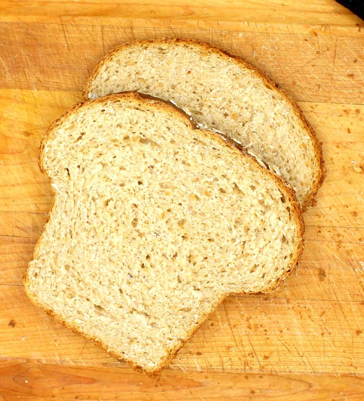 Slices of oatmeal bread on chopping board.