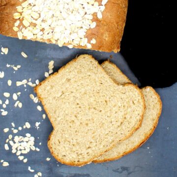Oatmeal Bread, sliced, with oats strewn around.