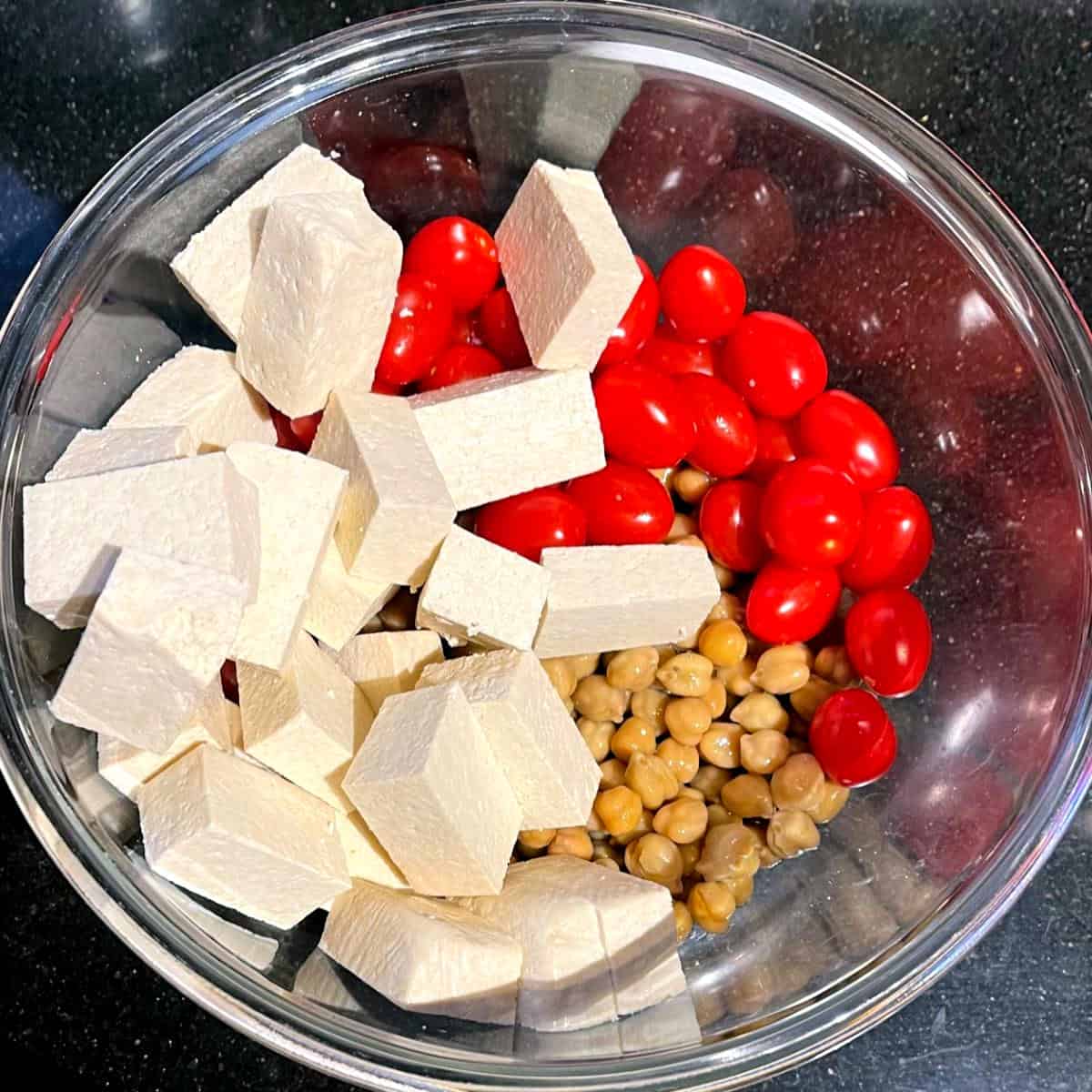 Chickpeas,c cherry tomatoes and tofu in bowl.