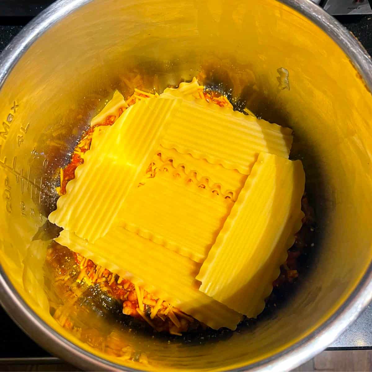 Layer of noodles in slow cooker liner.